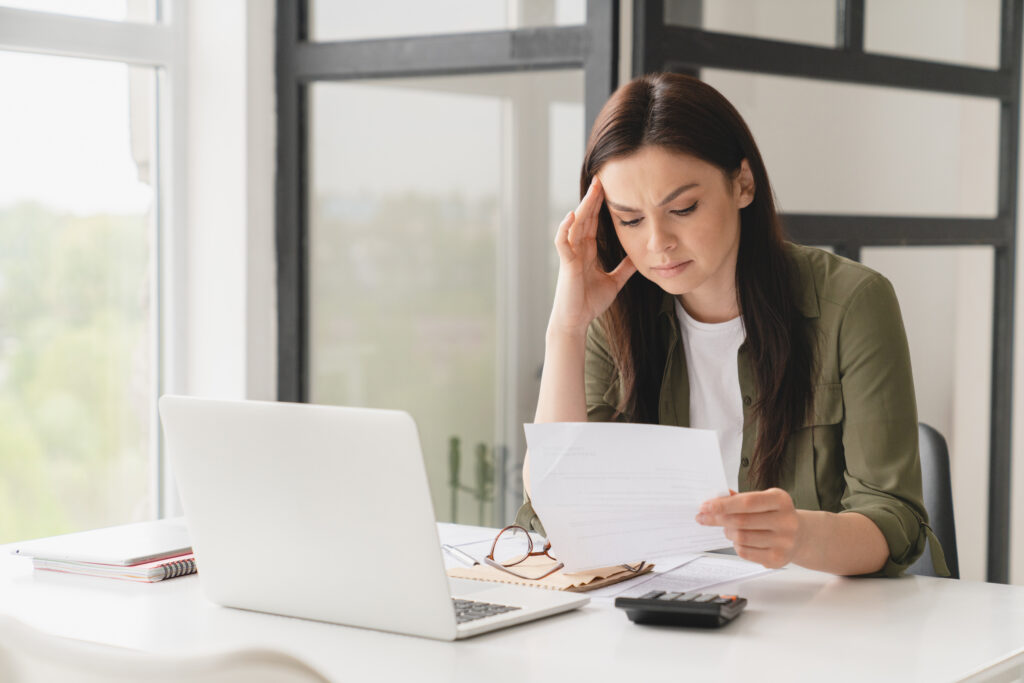 Frustrated woman looking at paper, dealing with insurance fraud