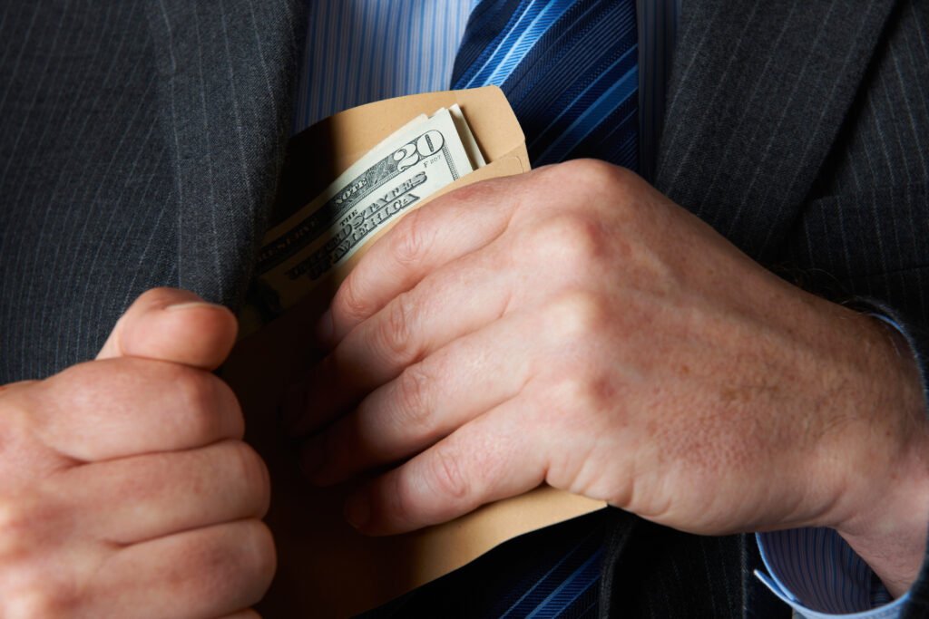 Businessman Putting Envelop of Dollars In Pocket