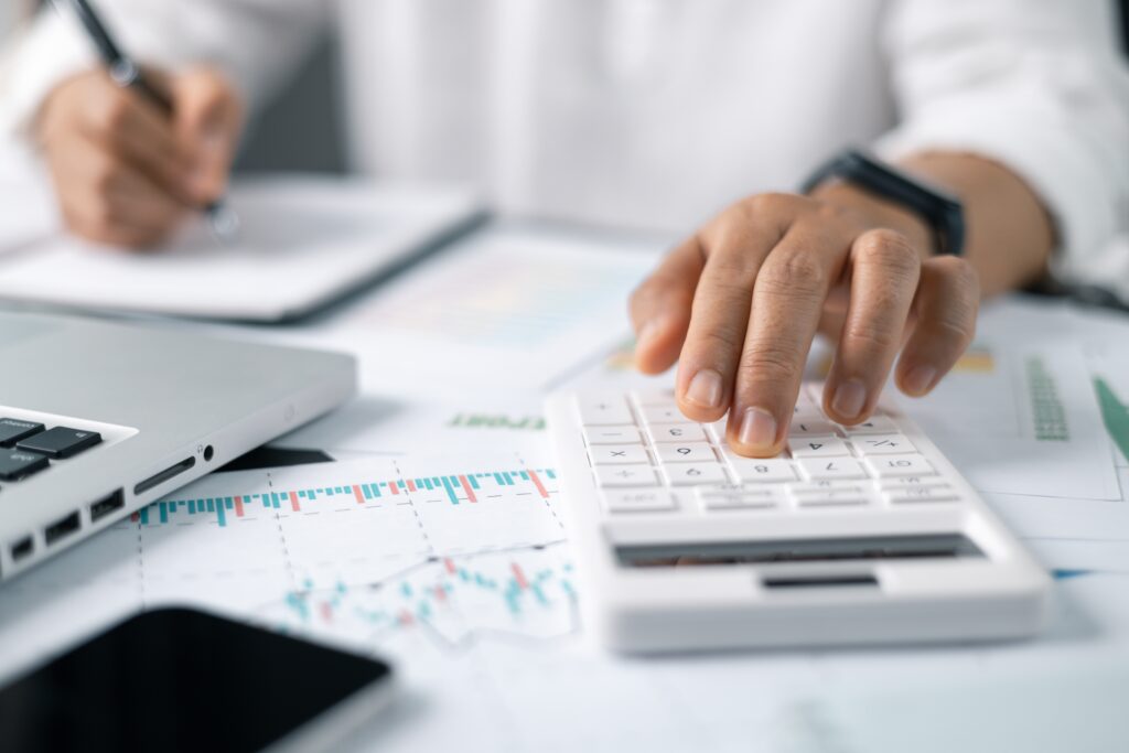Businesswoman doing finances and using calculator on desk