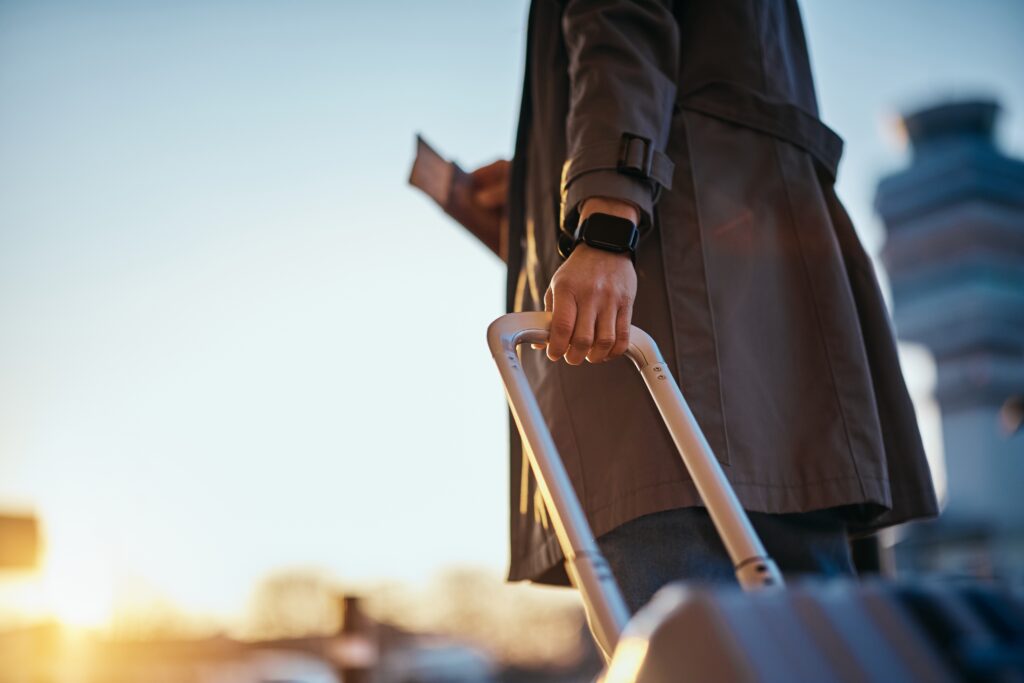 Close up of woman with travel bag at the airport at sunset