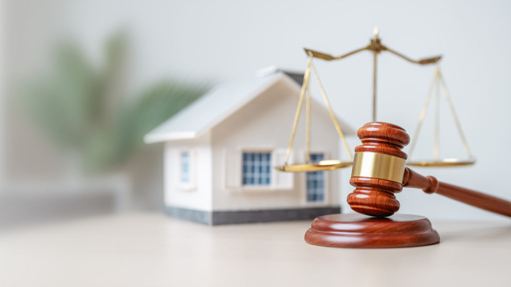 A scale with a gavel and a house in the background